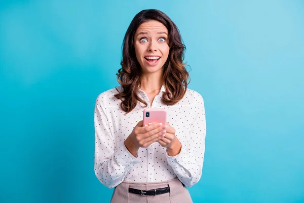 Портрет впечатленной брюнетки девушка держать телефон носить рубашку изолированы на бирюзовом фоне цвета — стоковое фото