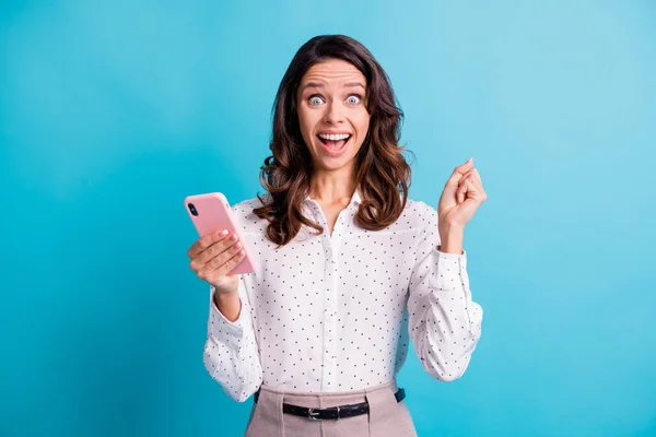 Фото впечатленной брюнетки ура девушка держать телефон носить рубашку изолированы на бирюзовом фоне — стоковое фото