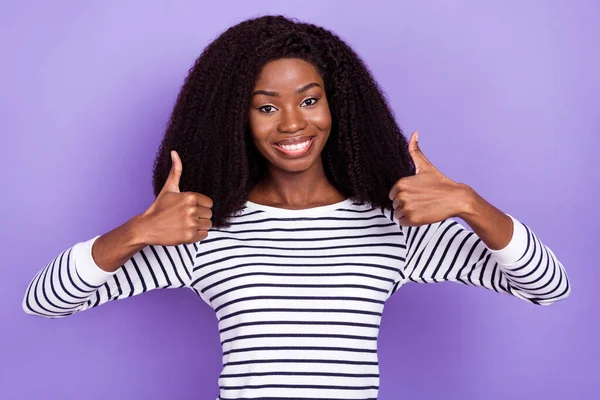 Foto de la señora joven divertida mostrar pulgar hacia arriba usar suéter a rayas aislado sobre fondo de color violeta — Foto de Stock