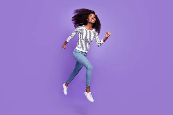 Full length profile φωτογραφία του αστείου millennial κυρία τρέχει φορούν πουλόβερ τζιν απομονώνονται σε βιολετί φόντο χρώμα — Φωτογραφία Αρχείου