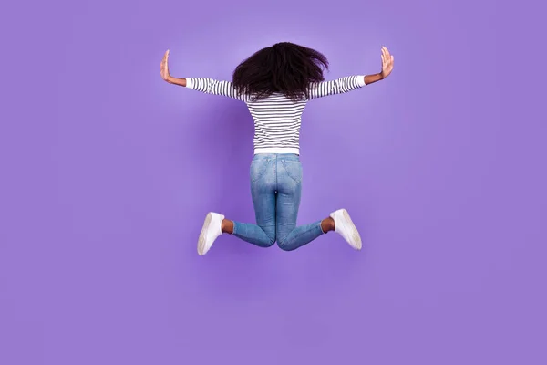 Full body back photo of cool millennial lady jump wear pullover jeans isolated on violet color background — Stock Photo, Image