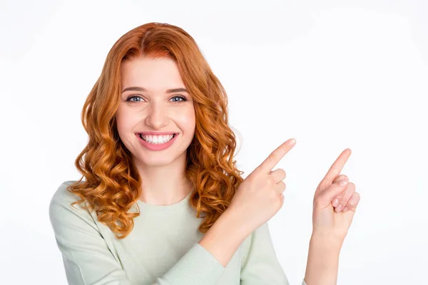 Foto portrét červené vlasy žena s úsměvem ukazující prstem prázdný prostor reklama izolované bílé barvy pozadí — Stock fotografie