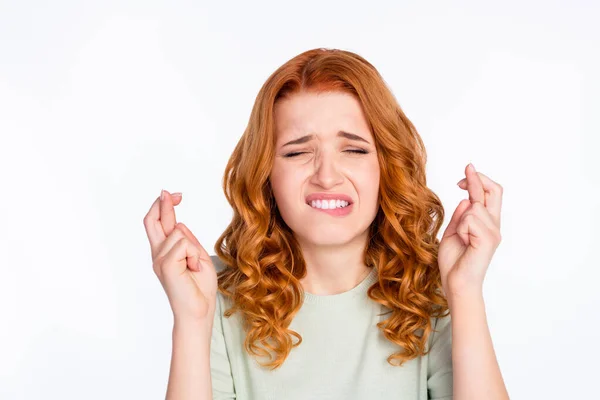 Foto ritratto di donna dai capelli rossi mordere le labbra con le dita incrociate speranza di fortuna isolato sfondo di colore bianco — Foto Stock