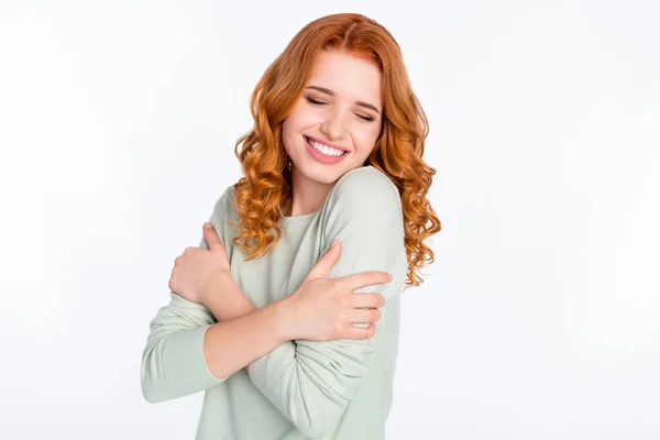 Фотопортрет рыжеволосой девушки мечтательный положительный обнимая себя улыбаясь закрытые глаза изолированный белый цвет фона — стоковое фото