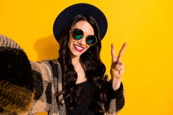 Fotografie de femeie tânără destul de fericită poartă ochelari cool face fata selfie v-semn izolat pe fundal de culoare galbenă — Fotografie, imagine de stoc