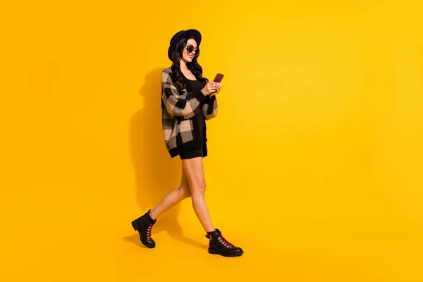 Πλήρης εικόνα προφίλ μέγεθος πλευρά της ευτυχούς μελαχρινή blogger κορίτσι πάει κενό χώρο ματιά τηλέφωνο απομονώνονται σε κίτρινο χρώμα φόντο — Φωτογραφία Αρχείου