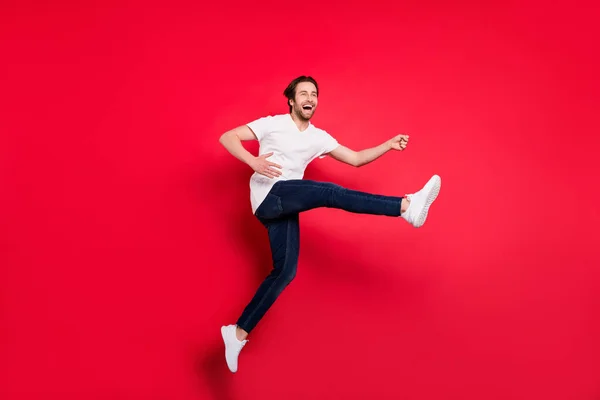 Pleine taille profil côté photo de jeune gars heureux sourire positif sauter vers le haut jouer guitare artiste isolé sur fond rouge — Photo