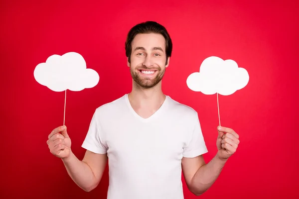 Foto van vrolijke vrolijke jongeman houd handen wolken voorspellen goede stemming geïsoleerd op rode kleur achtergrond — Stockfoto