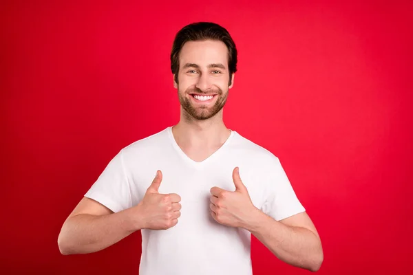 Photo de charmant heureux jeune homme positif montrer pouces vers le haut sourire bonne humeur isolé sur fond de couleur rouge — Photo