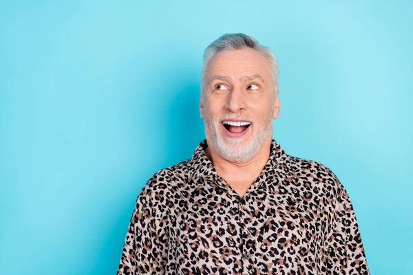 Фотографія сірого волосся старший чоловік виглядає порожнім простором сорочки леопарда ізольовані на яскраво-блакитному фоні — стокове фото