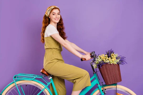 Profile side view portret atrakcyjnej wesołej dziewczyny jazda na rowerze spędzanie dnia izolowane na fioletowy fioletowy kolor tła — Zdjęcie stockowe