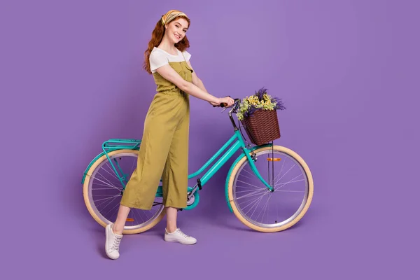 Comprimento total do corpo tamanho vista de menina muito alegre gostando de andar de bicicleta isolada sobre violeta cor roxa fundo — Fotografia de Stock