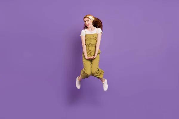 全身サイズビューの魅力的な陽気な恥ずかしがり屋の女の子ジャンプ楽しみを持っています分離上の紫の色の背景 — ストック写真