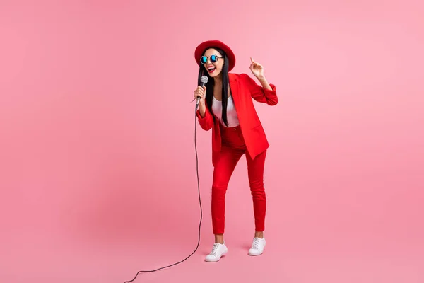 Volledige lengte foto portret van opgewonden meisje zingen holding mic in een hand geïsoleerd op pastel roze gekleurde achtergrond — Stockfoto