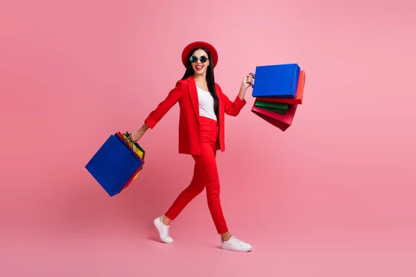 Foto portret volledige lichaam zijaanzicht van vrouw wandelen met boodschappentassen geïsoleerd op pastel roze gekleurde achtergrond — Stockfoto