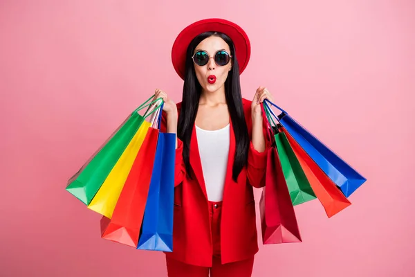 Foto porträtt av förvånad kvinna med shoppingpåsar isolerade på pastell rosa bakgrund — Stockfoto