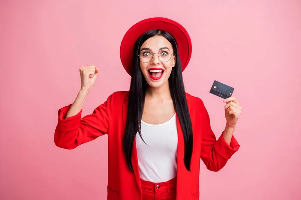 Foto retrato de una loca mujer celebrando sosteniendo tarjeta de crédito en una mano aislada sobre fondo de color rosa pastel —  Fotos de Stock