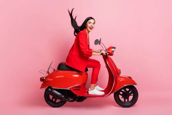 Full size profiel zijkant foto van jonge gekke opgewonden glimlachend meisje rijden bromfiets snel extreme geïsoleerd op roze kleur achtergrond — Stockfoto