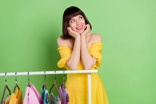 Φωτογραφία από θετική χαρούμενη νεαρή γυναίκα ματιά κενό χώρο showroom όνειρο κρεμάστρα απομονώνονται σε πράσινο φόντο χρώμα — Φωτογραφία Αρχείου