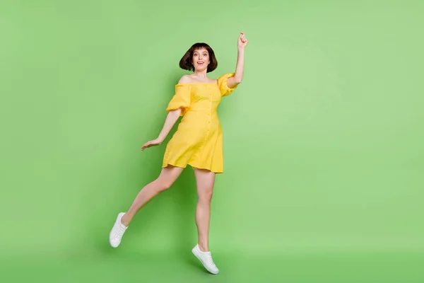 Full längd foto av charmiga positiva unga kvinna hålla händerna fånga paraply isolerad på grön färg bakgrund — Stockfoto
