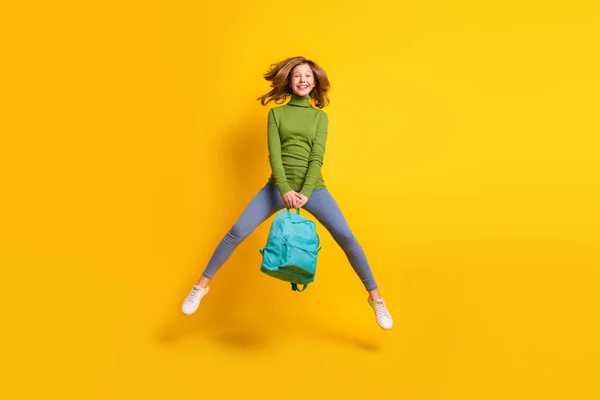 Tamanho total do corpo foto menina pulando usando mochila sorrindo isolado vibrante cor amarela fundo — Fotografia de Stock