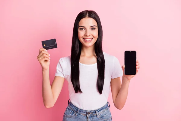 Πορτρέτο της ελκυστικό χαρούμενο κορίτσι που κατέχουν σε χέρια gadget τραπεζική κάρτα web order απομονώνονται σε ροζ παστέλ χρώμα φόντο — Φωτογραφία Αρχείου