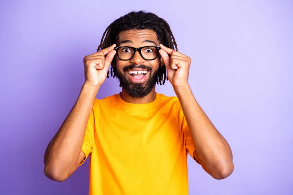 Portrét pěkné optimistické brunet chlap dotykové brýle nosit oranžové tričko izolované na pulzující šeříkové barvy pozadí — Stock fotografie