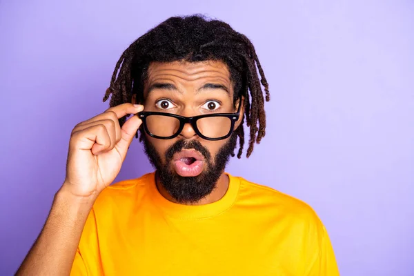 Foto de impressionado agradável morena homem olhar desgaste óculos amarelo t-shirt isolado na cor roxa fundo — Fotografia de Stock