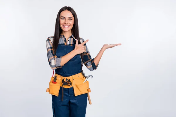 Foto van vrolijke vrolijke glimlachende vrouw in bouwer uniform reclame product object geïsoleerd op witte kleur achtergrond — Stockfoto