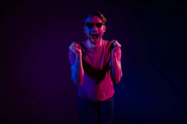 Portré vonzó vidám elkápráztatott vicces srác szórakozás örvendezik elszigetelt sötét neon lila szín háttér — Stock Fotó