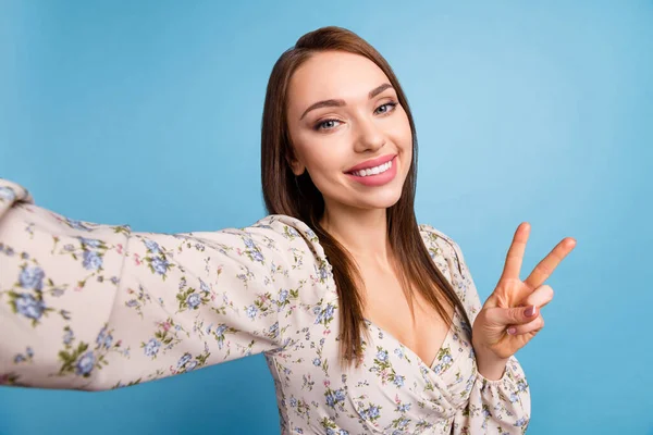 Foto van mooie bruine kapsel jonge dame doen selfie show v-teken slijtage bloemenblouse geïsoleerd op blauwe kleur achtergrond — Stockfoto