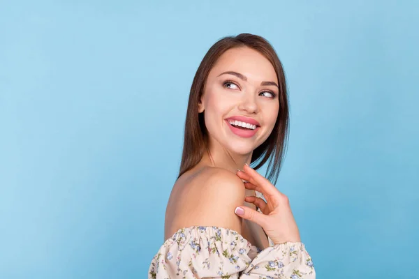 Profiel foto van onder de indruk brunette kapsel millennial dame kijken lege ruimte dragen bloemenblouse geïsoleerd op blauwe kleur achtergrond — Stockfoto