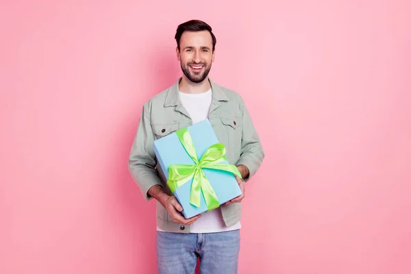 Retrato de cara alegre atraente segurando em mãos giftbox isolado sobre cor pastel rosa fundo — Fotografia de Stock