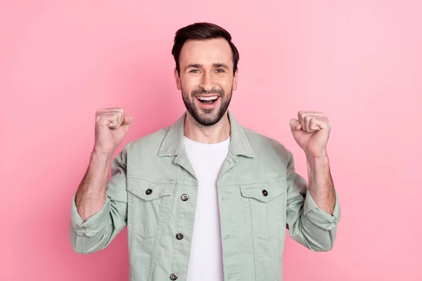 Photo of nice hooray brunet man hands fists wear grey shirt isolated on pastel pink color background — Stock Photo, Image