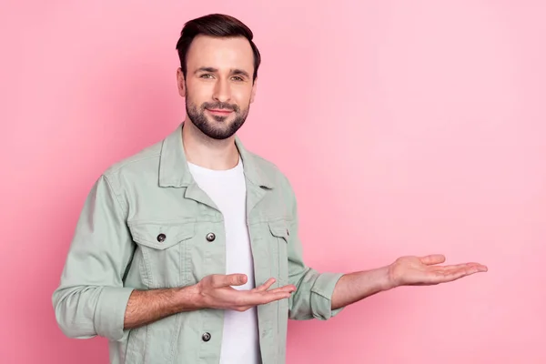 Photo of nice optimistic brunet man point empty space wear grey shirt isolated on pastel pink color background — Stock Photo, Image