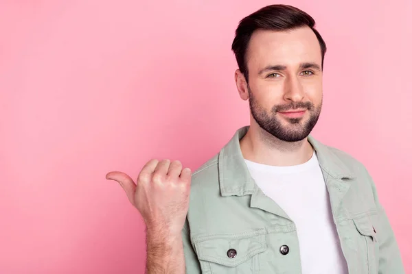 Photo of nice optimistic brunet man point empty space wear grey shirt isolated on pastel pink color background — Stock Photo, Image