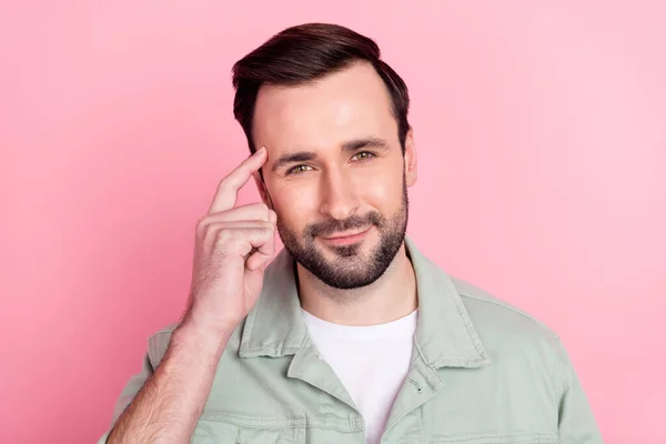 Foto de la bonita morena optimista hombre dedo cabeza desgaste camisa gris aislado sobre fondo de color rosa pastel — Foto de Stock