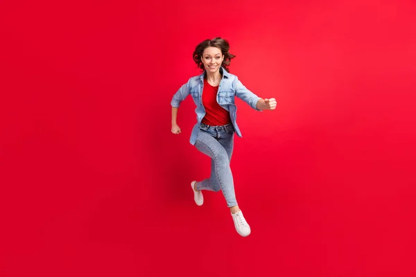 Teljes hossz testméret fotó vidám lány ugrás fel fut gyorsan elszigetelt élénk piros szín háttér — Stock Fotó