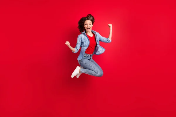 Tamanho do corpo de comprimento total foto da menina saltando para cima gesticulando como vencedor isolado no fundo de cor vermelha vibrante com copyspace — Fotografia de Stock