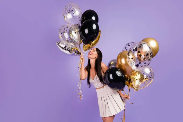 Foto del lado del perfil de la joven encantadora chica sonriente bastante positiva sostiene globos disfrutando de fin de semana aislado sobre fondo de color púrpura —  Fotos de Stock