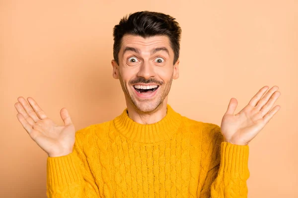 Fotoporträt des überraschten überglücklichen Kerls gestikuliert mit lächelnden Händen isoliert auf pastellbeigem Hintergrund — Stockfoto