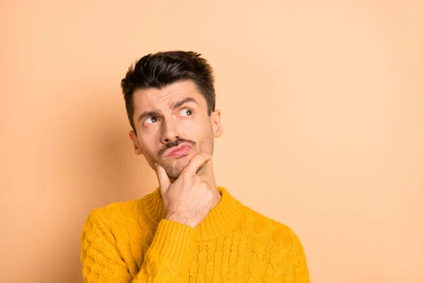 Foto-Porträt von nachdenklichen neugierigen Mann suchen leeren Raum berühren Kinn isoliert auf pastellbeige Hintergrund — Stockfoto