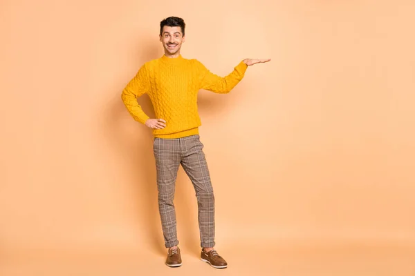 Foto retrato vista de cuerpo completo del hombre mostrando el tamaño de espacio en blanco con la mano aislada sobre fondo de color beige pastel — Foto de Stock