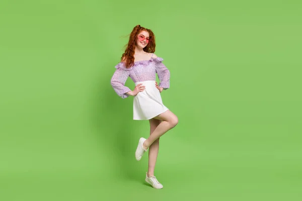 Foto em tamanho completo de otimista penteado vermelho jovem senhora stand desgaste blusa saia óculos isolados no fundo de cor verde — Fotografia de Stock