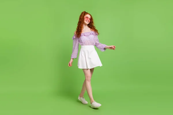 Foto de comprimento total de menina penteado vermelho jovem senhora ir usar blusa saia óculos isolados no fundo de cor verde — Fotografia de Stock