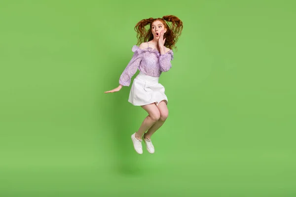 Foto em tamanho completo de impressionado penteado vermelho jovem senhora salto desgaste blusa óculos saia isolada no fundo de cor verde — Fotografia de Stock