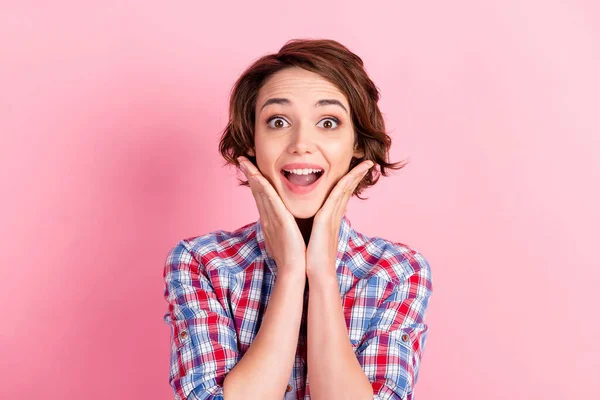 Foto portrét vzrušené šťastný dívka s otevřenými ústy dotýkající tvář tváře se dvěma rukama izolované na pastelové růžové barevné pozadí — Stock fotografie