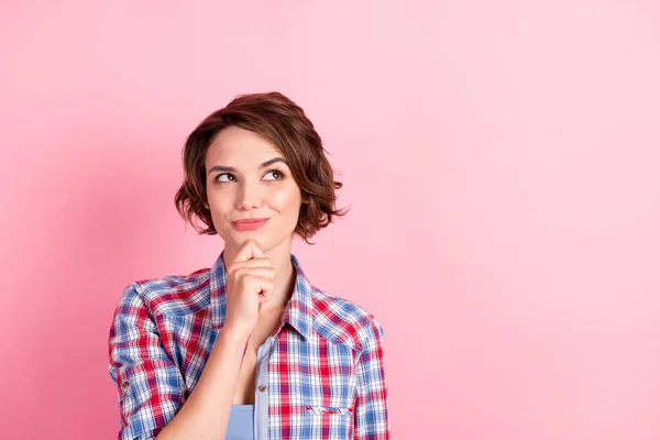 Foto portret van sluwe meisje aanraken gezicht kin met vinger kijken naar lege ruimte geïsoleerd op pastel roze gekleurde achtergrond — Stockfoto