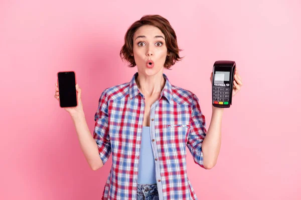 Foto von lustig überrascht Frau tragen kariertes Hemd hält moderne Gadget Bank Terminal isoliert rosa Hintergrund — Stockfoto
