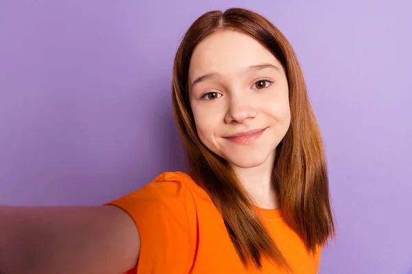 Foto de optimista chica de pelo de jengibre agradable hacer selfie desgaste naranja camiseta aislada sobre fondo de color púrpura —  Fotos de Stock